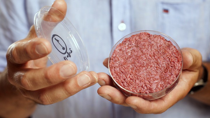 Professor Mark Post Holds The World's First Lab Grown Beef Burger During A Launch Event In West London